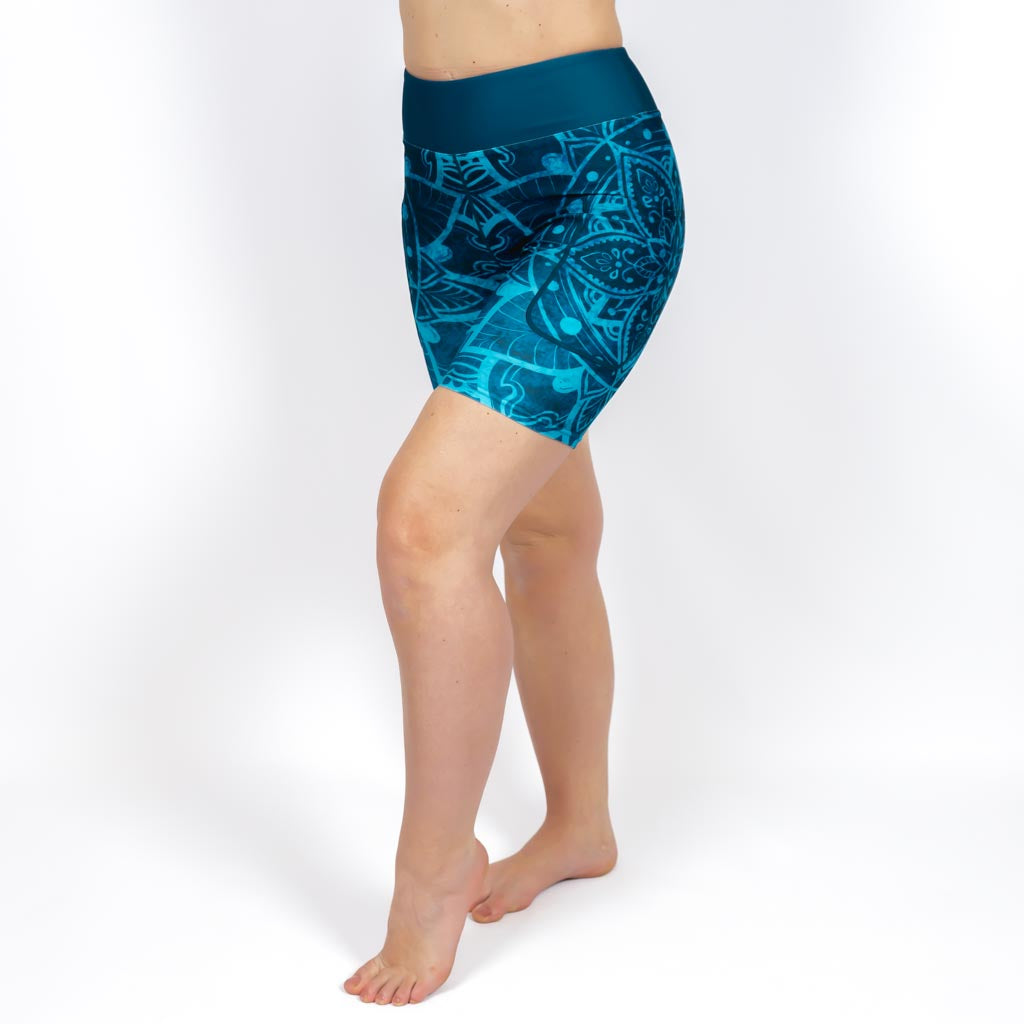 Kvinde i højtaljede mønstrede shorts. Shorts har lommer på begge sider. Meget elastiske og squat proof. 
