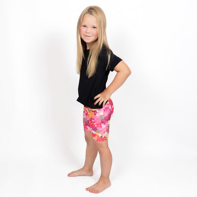 Barn i højtaljede mønstrede shorts. Meget elastiske og perfekt til leg og hverdag. Ikke gennemsigtige.