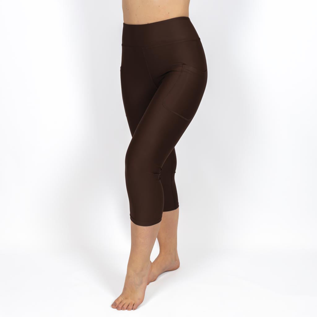 Kvinde i højtaljede ensfarvet capris. Capris har lommer på begge sider. Meget elastiske og squat proof. 