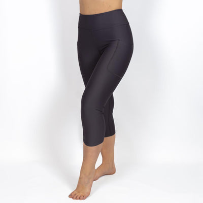 Kvinde i højtaljede ensfarvet capris. Capris har lommer på begge sider. Meget elastiske og squat proof. 