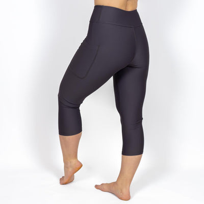 Kvinde i højtaljede ensfarvet capris. Capris har lommer på begge sider. Meget elastiske og squat proof. 