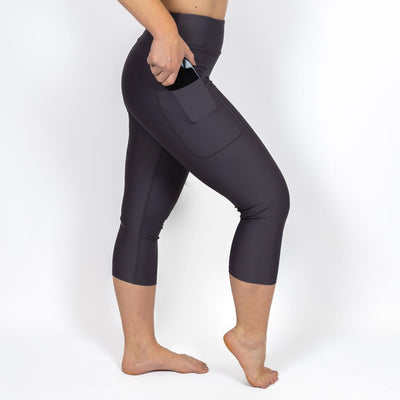 Kvinde i højtaljede ensfarvet capris. Capris har lommer på begge sider. Meget elastiske og squat proof. 