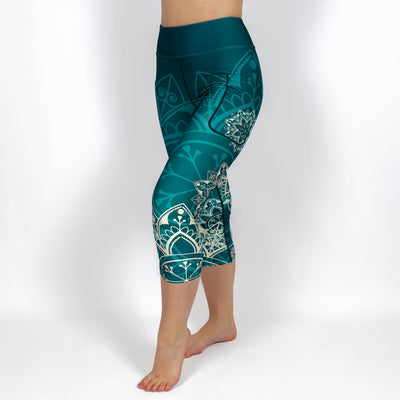 Kvinde i højtaljede mønstrede capris. Capris har lommer på begge sider. Meget elastiske og squat proof. 
