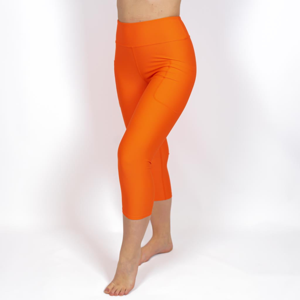 Kvinde i højtaljede ensfarvet capris. Capris har lommer på begge sider. Meget elastiske og squat proof. 