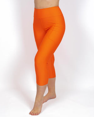 Kvinde i højtaljede ensfarvet capris. Capris har lommer på begge sider. Meget elastiske og squat proof. 