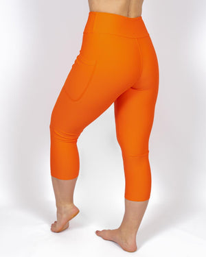 Kvinde i højtaljede ensfarvet capris. Capris har lommer på begge sider. Meget elastiske og squat proof. 