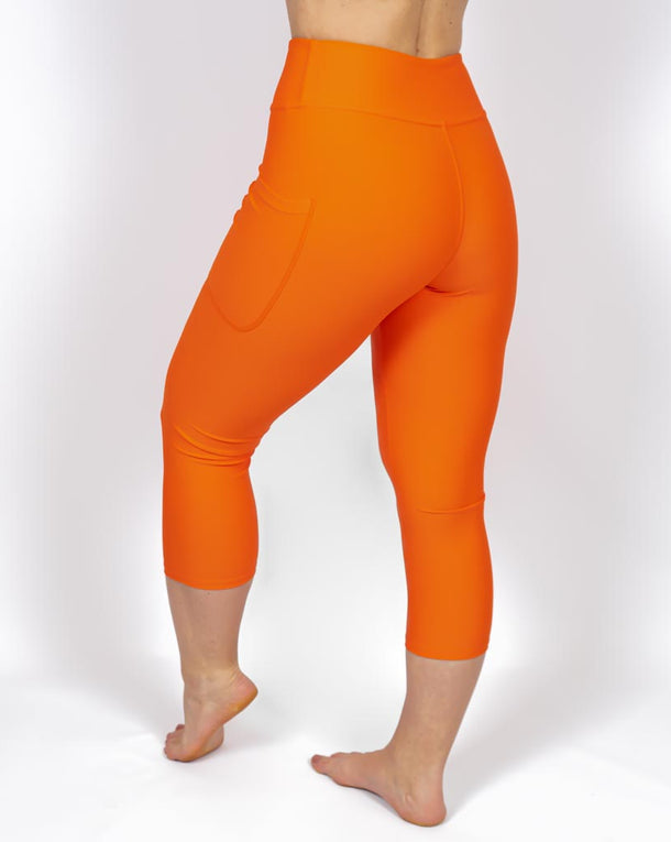 Kvinde i højtaljede ensfarvet capris. Capris har lommer på begge sider. Meget elastiske og squat proof. 