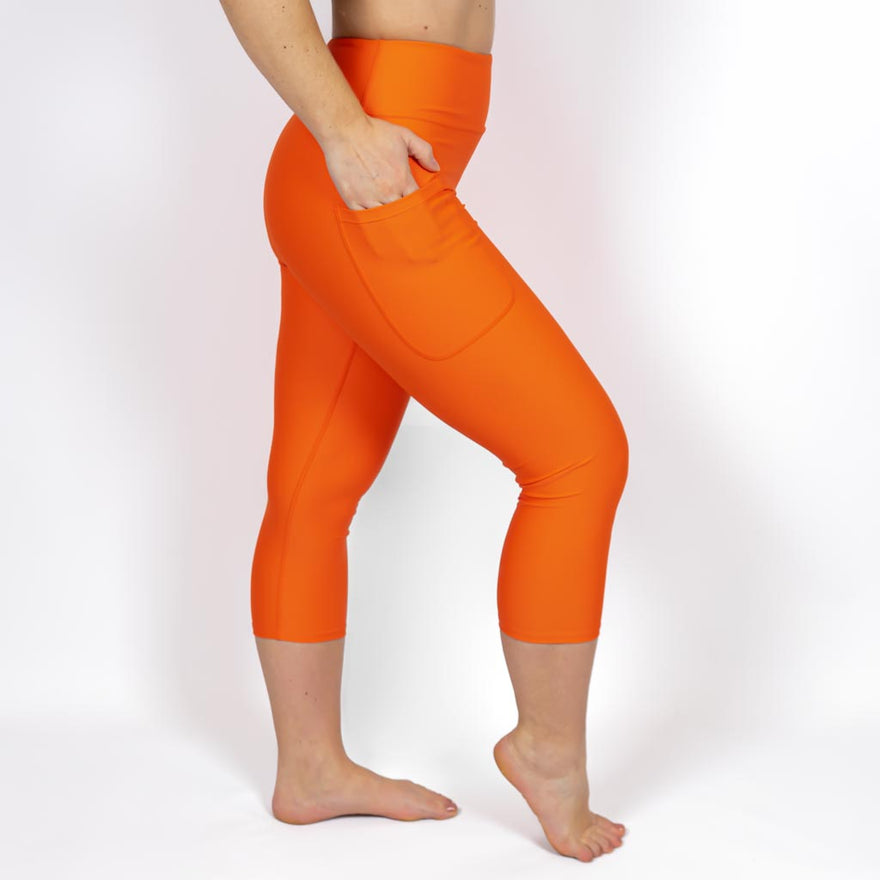 Kvinde i højtaljede ensfarvet capris. Capris har lommer på begge sider. Meget elastiske og squat proof. 