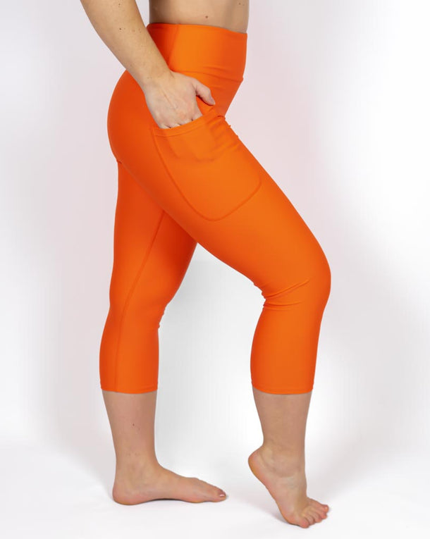 Kvinde i højtaljede ensfarvet capris. Capris har lommer på begge sider. Meget elastiske og squat proof. 