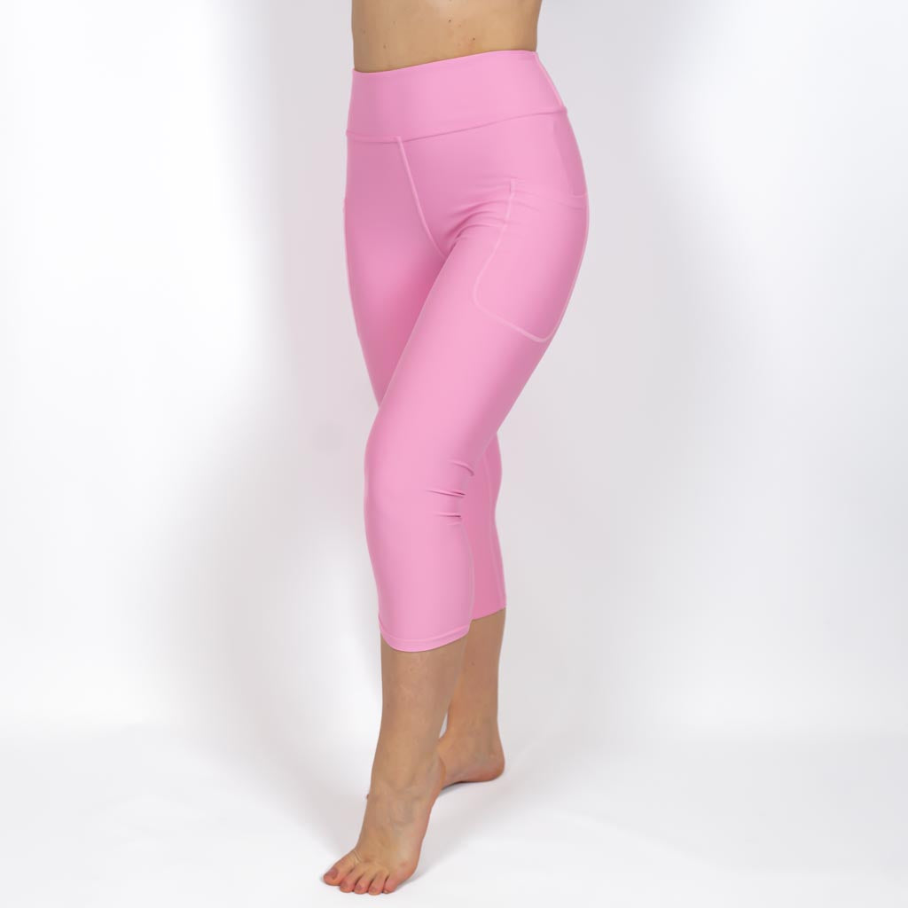 Kvinde i højtaljede ensfarvet capris. Capris har lommer på begge sider. Meget elastiske og squat proof. 