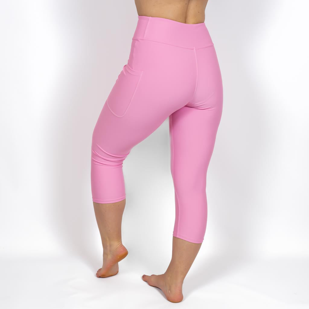 Kvinde i højtaljede ensfarvet capris. Capris har lommer på begge sider. Meget elastiske og squat proof. 