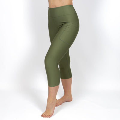 Kvinde i højtaljede ensfarvet capris. Capris har lommer på begge sider. Meget elastiske og squat proof. 