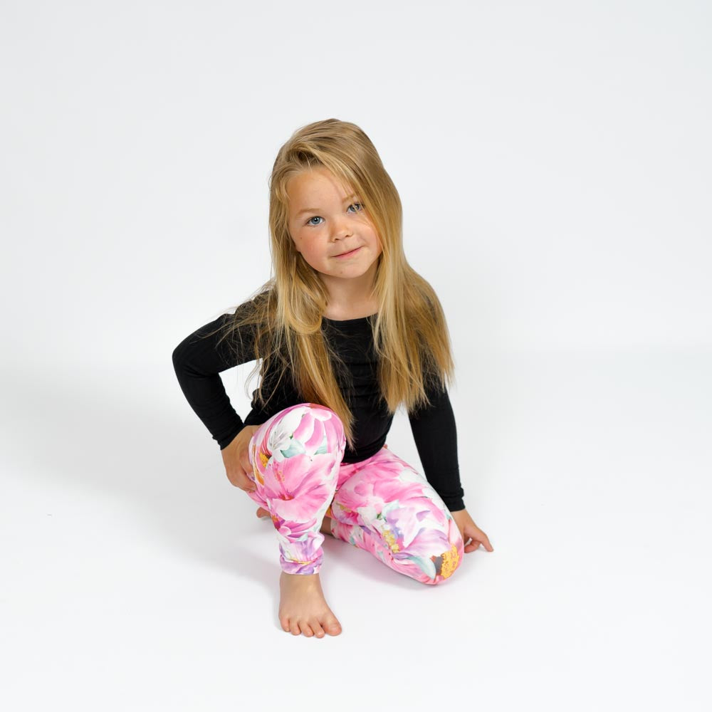 Barn i højtaljede mønstrede leggings. Meget elastiske og perfekt til leg og hverdag. Ikke gennemsigtige.