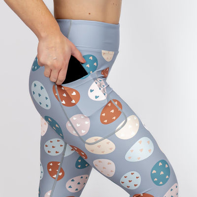 Kvinde i højtaljede mønstrede leggings. Tights har lommer på begge sider. Meget elastiske og squat proof.